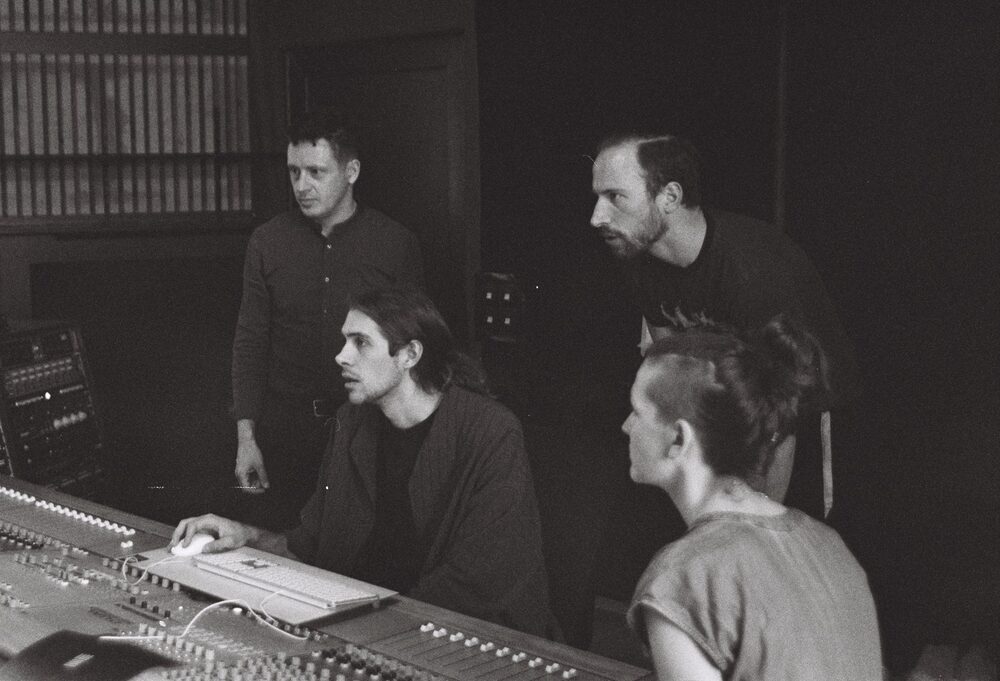 Monom, four people gathered around the mixing console