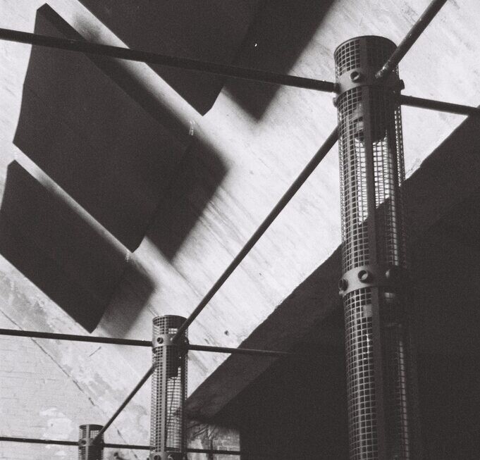 Monom, acoustic mesh columns against the ceiling