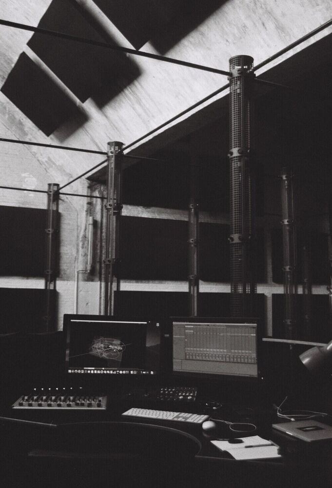 Desk view of the 4D Sound spatial positioning software, acoustic towers in the background, Monom